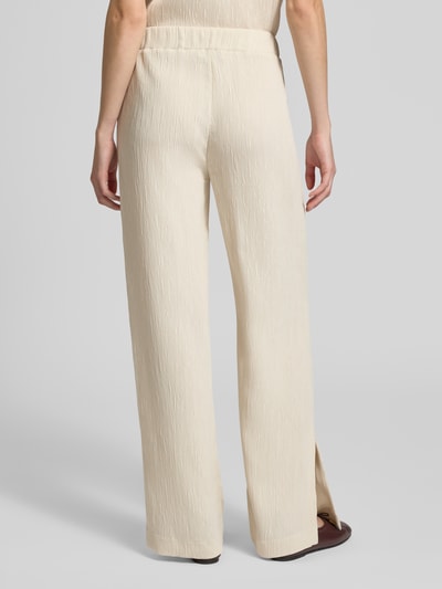 Frauenmodel trägt Wide Fit Stoffhose aus Viskose-Mix Modell 'Mucia' von OPUS PANTS mit Strukturmuster, elastischem Bund, Ganzkörperansicht Rückansicht.