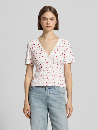 Frauenmodel trägt Blusenshirt in Pointelle-Optik Modell 'Vianne' von OH APRIL aus Reine Baumwolle, V-Ausschnitt, Spitzenbesatz, Knopfleiste, Ganzkörperansicht von vorne.