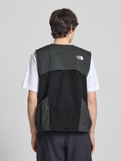 Männermodel trägt Regular Fit Weste mit Logo-Stitching von The North Face, Material-Mix, Schwarz mit Muster, Rückenlänge 63 cm, Ganzkörperansicht Rückansicht.