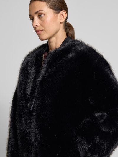 Frauenmodel trägt Jacke aus Kunstfell mit Stehkragen und Reißverschluss von Armani Exchange, Schwarz, weiche Textur, Nahaufnahme Oberkörper. Kontext: Damen Jacke von Armani Exchange, Kunstfell, Stehkragen, Reißverschluss, Abschlüsse aus Rippstrick, Rückenlänge bei Größe S 70 cm, Schulterbreite 50 cm, Brustweite 58 cm, Ärmellänge 60 cm.