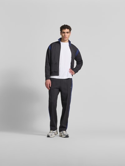 Männermodel trägt Regular Fit Sweatjacke mit Stehkragen von Kenzo in Dunkelblau mit blauen Details, elastische Abschlüsse, Reißverschluss, Eingrifftaschen, Rückenlänge 67 cm, Schulterbreite 51 cm, Ärmellänge 61 cm, Ganzkörperansicht von vorne.