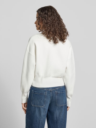 Modelka nosi kardigan z mieszanki bawełny i wiskozy, krój regular fit, model 'Compact' od Topshop, imitacja dzianiny, kolor biały, długość tyłu 50 cm, długość rękawów 55 cm, widok całej sylwetki z tyłu.