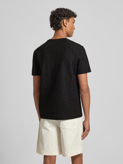 Mannelijk model draagt T-Shirt met Logo-Muster en ronde hals van ARMANI EXCHANGE, zwarte katoen, slim fit, ruglengte M 67 cm, volledige achteraanzicht.