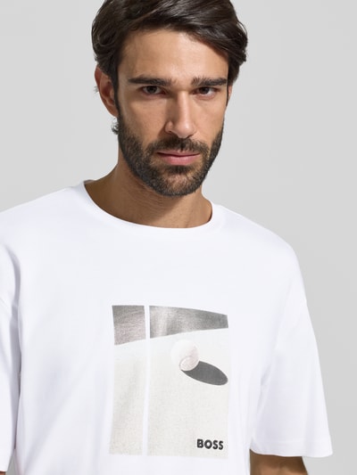 Mężczyzna nosi Relaxed Fit T-Shirt aus reiner Baumwolle Modell 'JOIN' od BOSS Green, biały, nadruk motyw, widok na górę ciała z przodu.