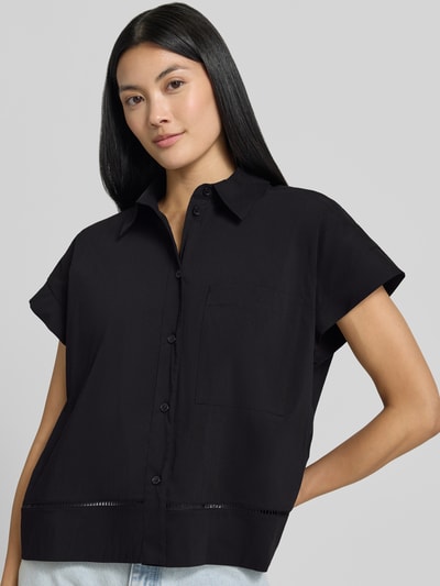 Frauenmodel trägt Relaxed Fit Hemdbluse mit Loch-Stitching Modell 'Fallerie' von OPUS im elastischen Baumwoll-Mix, kurzärmelig, schwarz, Knopfleiste, Hemdblusenkragen, Nahaufnahme Oberkörper.