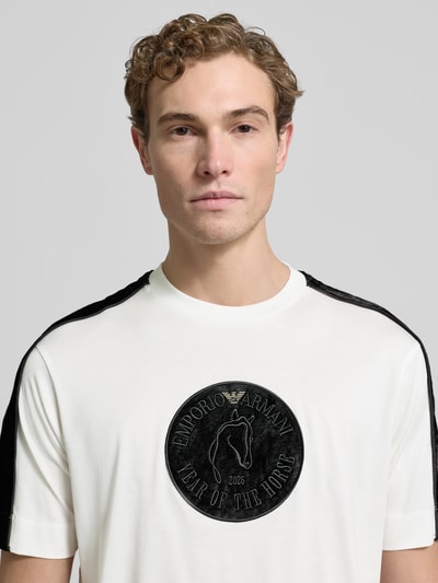 Männermodel trägt weißes Herren T-Shirt mit schwarzem Label-Detail von Emporio Armani, Lyocell-Baumwoll-Mix, Regular Fit, Nahaufnahme Oberkörper.