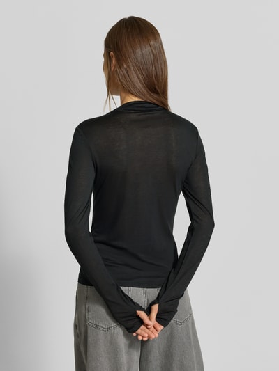 Frauenmodel trägt Longsleeve in semi-transparenter Optik von MYON, schwarz, eng anliegend, Rollkragen, Ziernaht, Lyocell-Woll-Mix, Ganzkörperansicht Rückansicht.