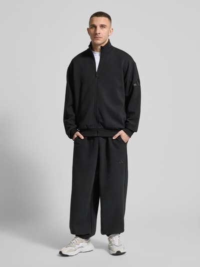 Männermodel trägt Loose Fit Sweatjacke mit Modal und Baumwoll-Anteil von adidas Sportswear, Optik: Unifarben, Material-Mix, Ganzkörperansicht von vorne
