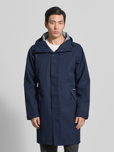Männermodel trägt dunkelblaue Regenjacke mit Reißverschlusstaschen Modell 'RAIN EATER' von GOFRANCK, Gerader-Schnitt, Kapuze, Label-Detail, Ganzkörperansicht von vorne.