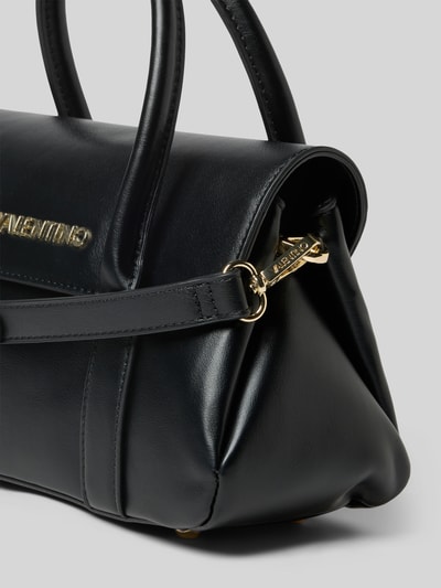Produktfoto, czarna Handtasche mit Label-Applikation von VALENTINO BAGS, złote okucia, matowa faktura, pasek na ramię, kontekst: damska torebka, główna komora z klapką i zapięciem magnetycznym, zamek błyskawiczny, odpinany pasek, szerokość 28 cm, długość 16 cm, głębokość 12 cm, pasek 125 cm.
