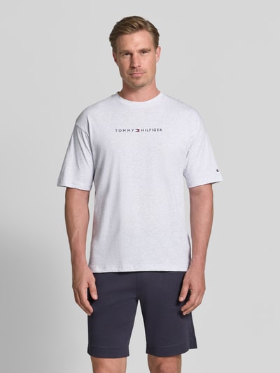 Männermodel trägt Regular Fit T-Shirt aus reiner Baumwolle von Tommy Hilfiger in effen kleuren, labelprint, jersey, ronde hals, korte mouw, ganzkörperansicht von vorne.