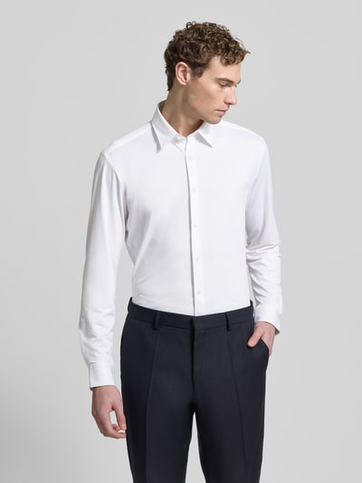 Męski model nosi Regular Fit Freizeithemd mit Kentkragen Model 'LIAM' od BOSS, jednokolorowy, popelina, wyhaftowane logo, długi rękaw, przód, ujęcie całej sylwetki.