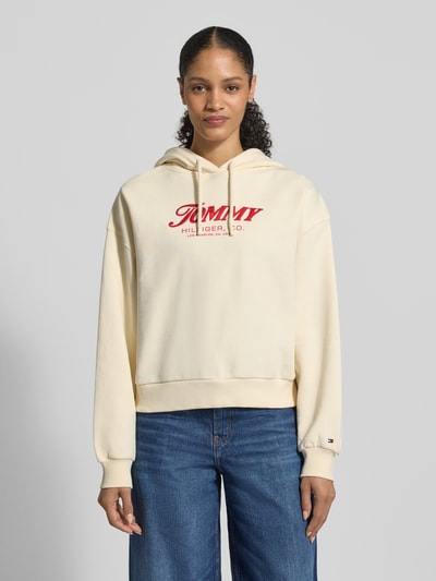 Frauenmodel trägt Regular Fit Hoodie aus reiner Baumwolle von Tommy Hilfiger, Optik: Unifarben, Label-Schriftzug, Langarm, Ganzkörperansicht von vorne.