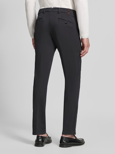 Männermodel trägt Regular Fit Chino aus Baumwoll-Mix Modell 'Lupus' von MMX, dunkles Material, glatte Struktur, Ganzkörperansicht Rückansicht.