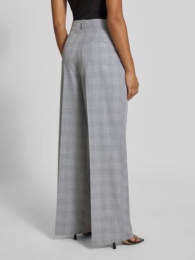 Frauenmodel trägt graue Weite Hose mit Viskose-Anteil von Jake*s Collection, dezentes Karomuster, Ganzkörperansicht Rückansicht.
