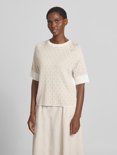Frauenmodel trägt Relaxed Fit Bluse aus Viskose-Mix mit Allover-Logo-Detail von Marc Cain in Creme mit Strick-Optik, Ganzkörperansicht von vorne, Damen Bluse mit Baumwoll-Anteil, Halbarm, Rundhalsausschnitt, Rückenlänge 54 cm, Ärmellänge 32 cm.