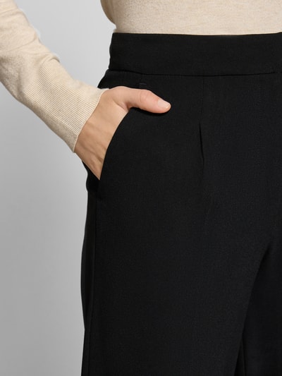 Frauenmodel trägt Stoffhose mit weitem Bein Modell 'TINNI' von SELECTED FEMME, Unifarbenes-Design, Seitliche Eingrifftaschen, Bügelfalten, Nahaufnahme Oberkörper.