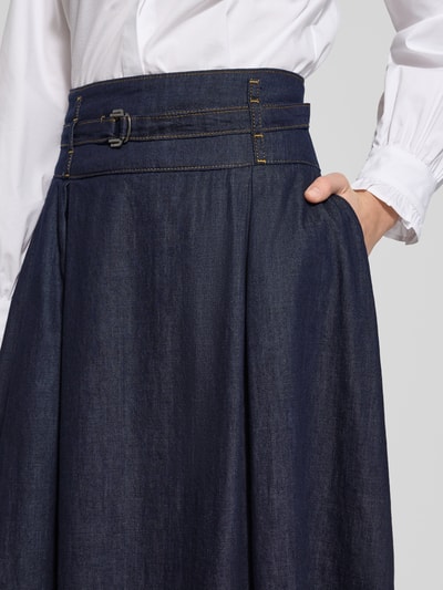 Frauenmodel trägt Midirock in Denim-Optik von More & More aus reiner Baumwolle, mit Stoffgürtel und Reißverschluss, Nahaufnahme Oberkörper.