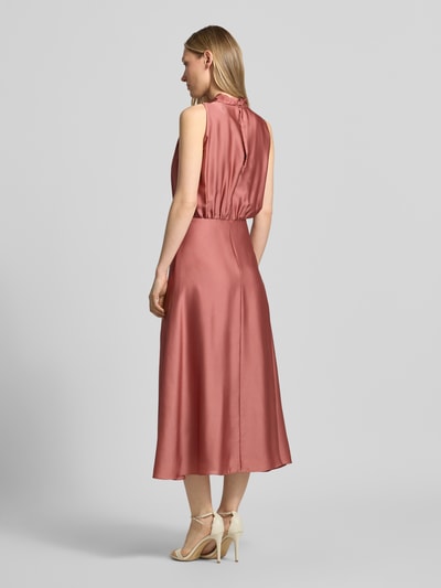 Kobiece modelka nosi Cocktailkleid mit Stehkragen von Swing w kolorze różowego satynowego materiału, taliowany krój, sukienka midi, zamek błyskawiczny z tyłu, halka pod sukienkę, długość tyłu w rozmiarze 36: 126 cm, szerokość w rozmiarze 36: 34 cm, widok całej sylwetki z tyłu