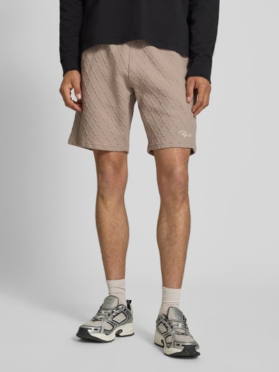 Männermodel trägt Relaxed Fit Shorts mit Strukturmuster Modell 'Jovren' von Pegador aus Elastischer-Material-Mix mit Baumwoll-Anteil in Beige, Ganzkörperansicht von vorne. Bundweite bei Größe M: 39 cm, Innenbeinlänge bei Größe M: 24 cm.
