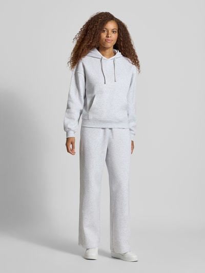 Kobiece model nosi jasnoszarą bluzę z kapturem Regular Fit Hoodie aus Baumwoll-Mix model 'BEST' od ONLY, gładka faktura, Ganzkörperansicht von vorne.