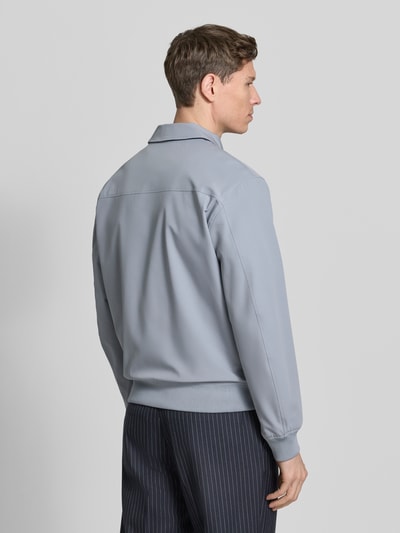 Mężczyznamodel nosi Blouson mit Kentkragen von JAKE*S STUDIO MEN w kolorze szarym, krój regular fit, długość tyłu w rozmiarze M: 60 cm, szerokość ramion w rozmiarze M: 48 cm, szerokość klatki piersiowej w rozmiarze M: 58 cm, długość rękawa w rozmiarze M: 67 cm, widok całej sylwetki od tyłu.