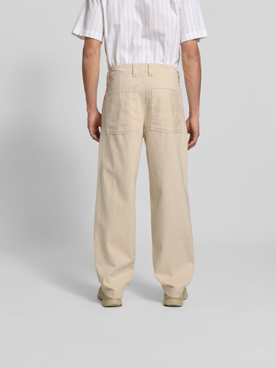 Männermodel trägt Straight Fit Jeans aus Reiner Baumwolle von ANNARR in Beige mit Gesäßtaschen und Gürtelschlaufen, Ganzkörperansicht Rückansicht.