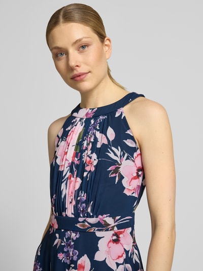 Frauenmodel trägt Midikleid mit floralem Allover-Print von Christian Berg Cocktail, taillierte Passform, ärmellos, Nahaufnahme Oberkörper.