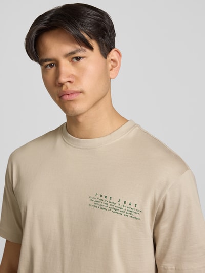 Männermodel trägt Regular Fit T-Shirt aus reiner Baumwolle Modell 'FRED' von Only & Sons, Optik: Unifarben, Motiv-Print, Nahaufnahme Oberkörper.
