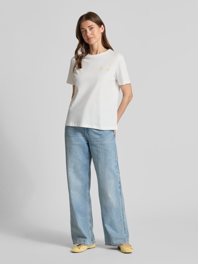 Frauenmodel trägt T-Shirt mit Rundhalsausschnitt Modell 'SYBILLA' von Vila aus Reine Baumwolle, Regular-Fit, Stitching, Rückenlänge 60 cm, Ganzkörperansicht von vorne.
