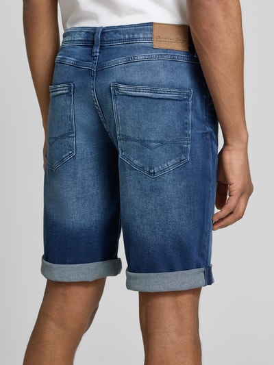 Männermodel trägt Bermudas im 5-Pocket-Design mit Aufschlag von Christian Berg Men, Baumwoll-Mix mit Stretch-Anteil, Ganzkörperansicht Rückansicht.