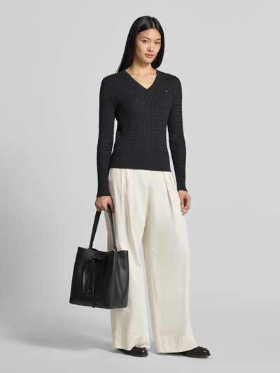 Damesmodel draagt Regular fit pullover uit puur katoen van Tommy Hilfiger, donkerblauw, met structuur, gecombineerd met witte broek, geheel aanzicht van voren.