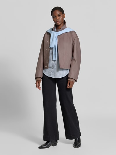 Frauenmodel trägt Jacke aus reiner Baumwolle von Victoria Beckham in Braun, kombiniert mit Hemd, Regular Fit, Stehkragen, Ganzkörperansicht von vorne.