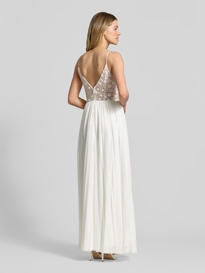 Frauenmodel trägt Brautkleid mit Ziersteinbesatz von Hey Kyla in Weiß, Falten-Optik, taillierte Passform, blickdichter Unterrock, Spaghettiträger, Ganzkörperansicht Rückansicht. Rückenlänge bei Größe 36: 122 cm, Brustweite bei Größe 36: 33 cm.