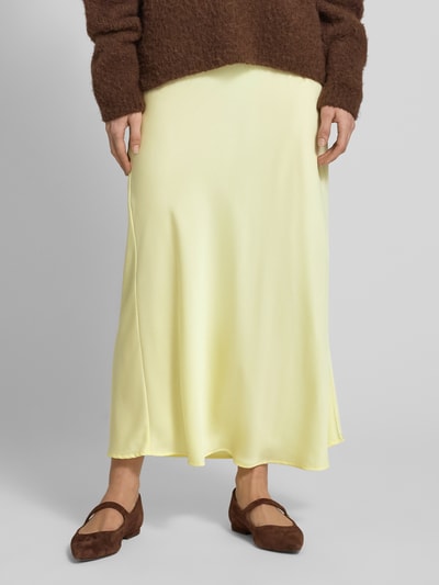 Frauenmodel trägt Maxirock aus Satin Modell 'VIELLETTE' von Vila in hellgelb, gerader Schnitt, High Waist, glatte Textur; Nahaufnahme Unterkörper.