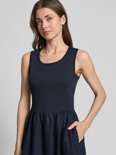 Frauenmodel trägt Midikleid mit Rundhalsausschnitt von Oui in Dunkelblau, reine Leinenstruktur, sichtbare Eingrifftaschen, Nahaufnahme Oberkörper.