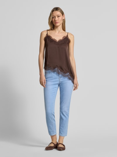 Frauenmodel trägt Jeans in verkürzter Passform Modell 'Mary' von Brax im hellblauen Baumwoll-Mix mit Eingrifftaschen, Ganzkörperansicht von vorne.