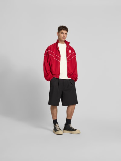 Männermodel trägt Regular Fit T-Shirt mit Label-Print von RHUDE aus reiner Baumwolle, Herren T-Shirt, Rundhalsausschnitt, Ganzkörperansicht von vorne.