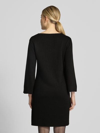Modelka nosi sukienkę mini Regular Fit Minikleid aus Viskose-Mix od MORE, czarny kolor, mieszanka wiskozy, dekolt w łódkę, rękaw o dł. 3/4, długość tyłu w rozmiarze 36: 87 cm, szerokość w rozmiarze 36: 42 cm, długość rękawów w rozmiarze 36: 51 cm, tekstura gładka, widok całej sylwetki z tyłu.