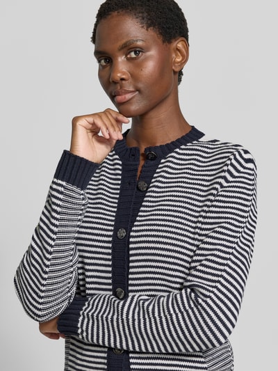 Frauenmodel trägt Strickjacke aus Baumwoll-Mix von Emporio Armani in Blau-Weiß mit Knopfleiste und elastischen Abschlüssen, Nahaufnahme Oberkörper.