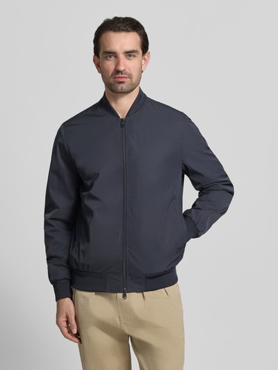 Männermodel trägt Regular Fit Jacke mit Stehkragen Modell 'Rapid' von CINQUE in Dunkelblau, glatte Struktur, Zweiwege-Reißverschluss, Ganzkörperansicht von vorne. Rückenlänge, Schulterbreite, Brustweite und Ärmellänge gemäß Größe M.