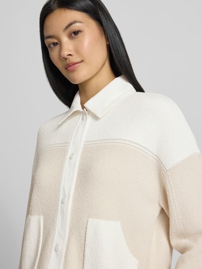 Frauenmodel trägt Regular Fit Jacke in Strick-Optik von Marc Cain, Farbverlauf in Creme und Weiß, Baumwoll-Mix, Nahaufnahme Oberkörper.