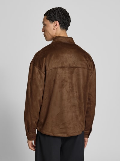 Męski model nosi Relaxed Fit Hemdjacke mit Brusttaschen Modell 'Madikeri' od Pegador, brązowa kurtka w skórzanym stylu, tekstura z zamszu, ciemnobrązowy kolor, krój relaxed fit, kołnierzyk kent, kieszenie na piersi, label-stitching, długość pleców w rozmiarze M: 69 cm, całkowity widok z tyłu.