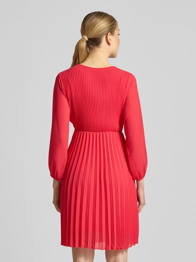 Frauenmodel trägt knielanges Kleid mit Plisseefalten Modell 'Im44sa' von ZABAIONE in Rot, taillierter Schnitt, Rückenansicht, Ganzkörperansicht Rückansicht.