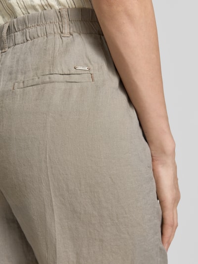 Frauenmodel trägt Leinenshorts mit Eingrifftaschen von Christian Berg Woman aus Reinem Leinen in Beige, Detailaufnahme Rückansicht. Damen, Regular-Fit, Bügelfalten, Bundweite 40 cm, Innenbeinlänge 22 cm.