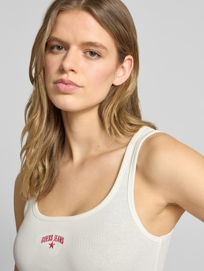 Vrouwenmodel draagt Tanktop in Ripp-Optik met Label-Stitching van Guess Jeans, mix van katoen en elastaan, slim fit, riblook, witte kleur, Nahaufnahme bovenlichaam.