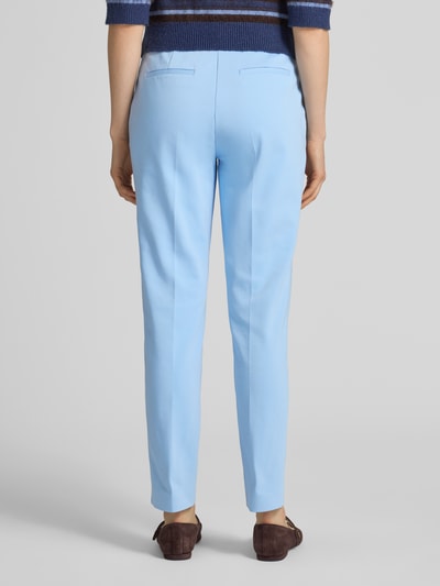 Modelka nosi Hose mit Bügelfalten od comma w kolorze jasnoniebieskim, krój slim fit, kieszenie z tyłu, bawełna ze stretchem, szerokość w rozmiarze 36: 38 cm, długość nogawki wewnętrznej w rozmiarze 36: 73 cm, widok całej sylwetki z tyłu.