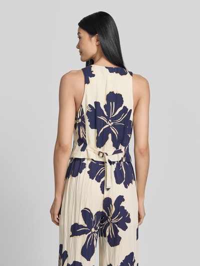 Frauenmodel trägt Weste aus Lyocell-Mix im Allover-Look Modell 'DOTTER' von MANGO, beige-blau, strukturierte Textur, Ganzkörperansicht Rückansicht.