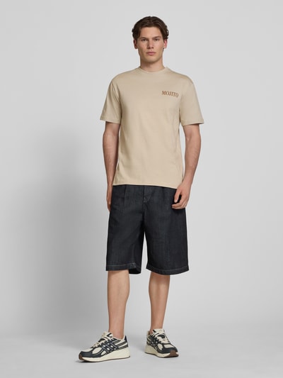 Mannenmodel draagt Regular Fit T-Shirt uit puur katoen model 'FRED' van Only & Sons, effen beige, jersey structuur, motiefprint, ronde hals, korte mouw, volledige vooraanzicht.