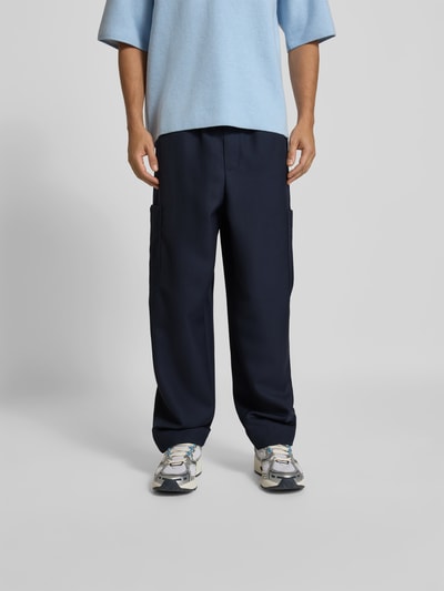 Männermodel trägt Regular Fit Leinenhose mit Cargotasche von Kenzo in Dunkelblau mit elastischem Bund und Gesäßtasche, Ganzkörperansicht von vorne.
